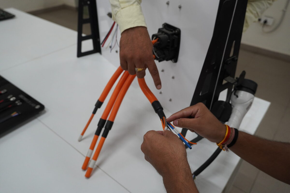 A trainer explains the cable connections of an EV mobility charging station at Bhartiya Skill Development University, Jaipur.