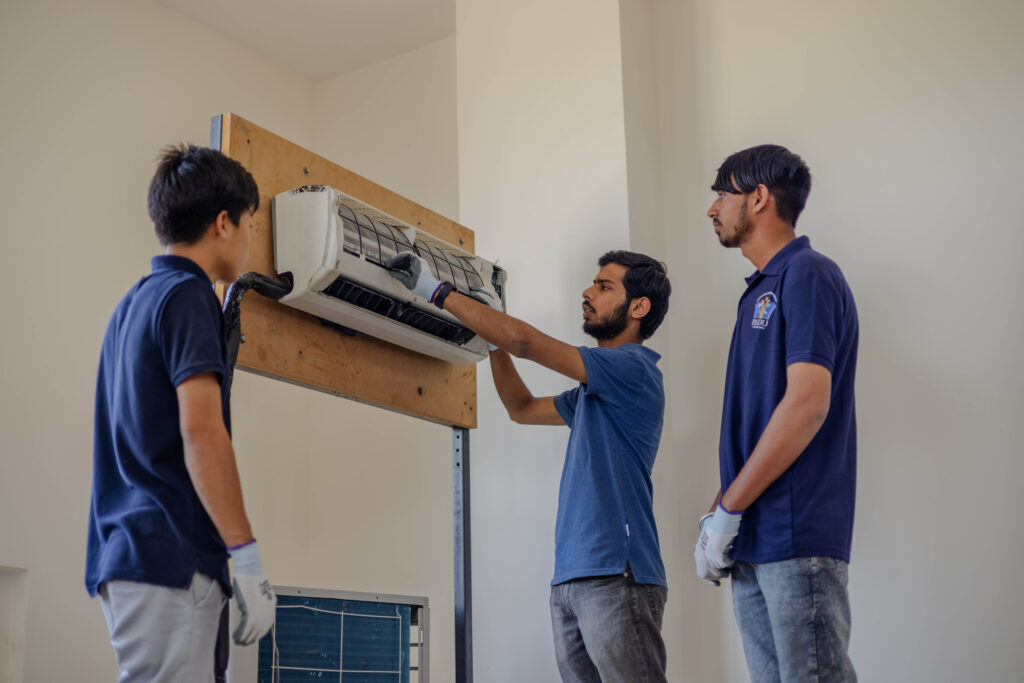 Trainer erklärt technische Anlage an Lernende im praxisorientierten Ausbildungskontext