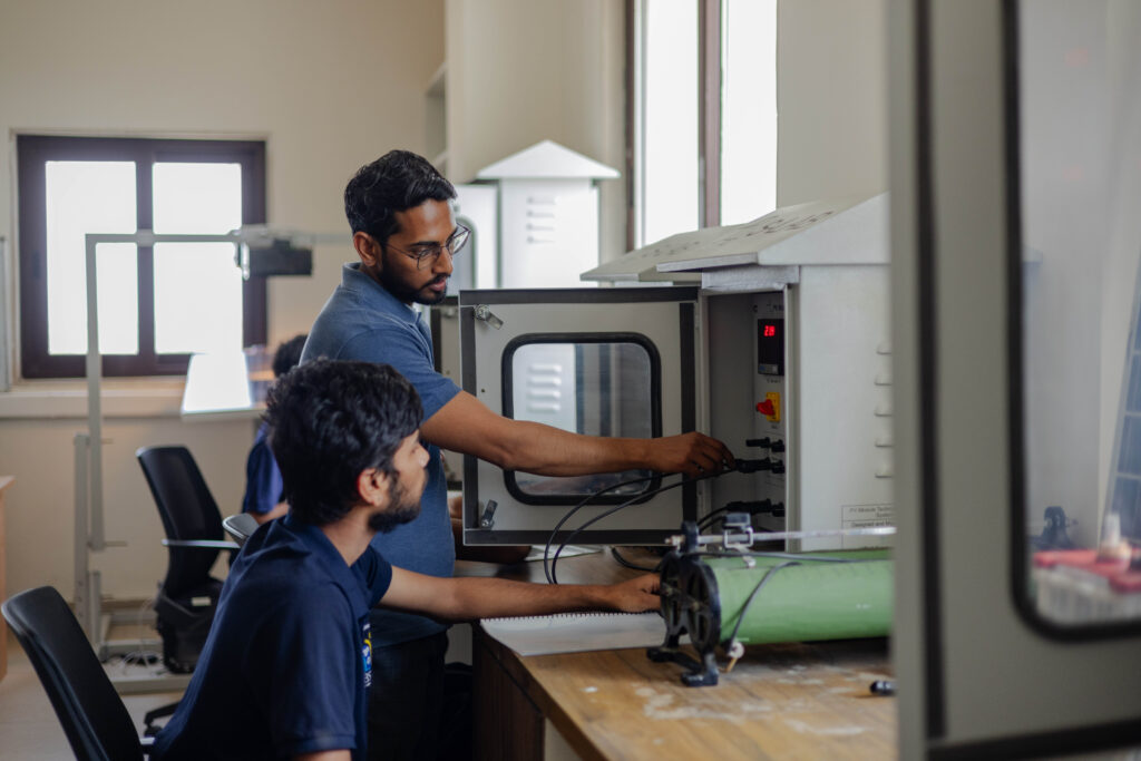 Trainer und Lernender prüfen technische Anlage und stellen Funktionsfähigkeit im Ausbildungsprozess sicher