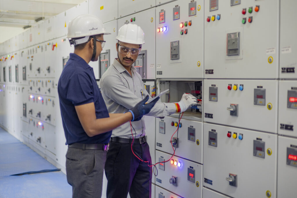 Trainer begleitet Lernende bei der Steuerung technischer Anlagen und verbindet Arbeitsprozess mit Kompetenzentwicklung